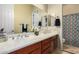 Double sink bathroom with wood cabinets, large mirror, and colorful shower curtain at 2554 E Honeysuckle Pl, Chandler, AZ 85286