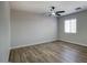 Empty bedroom featuring modern ceiling fan, wood flooring, and window for natural light at 2676 E Mineral Park Rd, San Tan Valley, AZ 85143