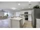 Modern kitchen featuring stainless steel appliances, a center island with seating, and an open layout to the living area at 2676 E Mineral Park Rd, San Tan Valley, AZ 85143