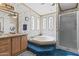 Bathroom featuring a sunken tub, vanity with a gold faucet, and a stand up shower at 2956 E Sequoia Dr, Phoenix, AZ 85050