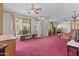 Open living room with red carpet, ceiling fans, and sliding glass doors at 2956 E Sequoia Dr, Phoenix, AZ 85050