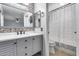 Bathroom with a gray vanity, white countertop, decorative mirror, and patterned shower curtain at 3178 W Williams Dr, Phoenix, AZ 85027