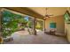 Covered patio with ceiling fan, TV, desert landscaping, and stone pavers for ultimate relaxation at 36813 N 109Th Way, Scottsdale, AZ 85262