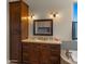 Bathroom vanity with dark wood cabinets, a bathtub, and an elegant mirror at 36813 N 109Th Way, Scottsdale, AZ 85262