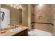 Bathroom featuring a tub and shower combo with tan tile surround, and a single sink vanity with tan countertops at 36813 N 109Th Way, Scottsdale, AZ 85262