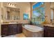 Bright bathroom featuring a soaking tub with decorative curtains and a granite vanity at 36813 N 109Th Way, Scottsdale, AZ 85262