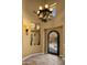 Elegant entryway featuring a decorative iron door, chandelier, and travertine flooring at 36813 N 109Th Way, Scottsdale, AZ 85262