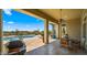 Covered patio featuring a ceiling fan, stone pillars, and a view of the pool and landscaped backyard at 36813 N 109Th Way, Scottsdale, AZ 85262