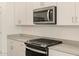 Stainless steel microwave and stove top cook range over white lower cabinets at 37168 W Prado St, Maricopa, AZ 85138