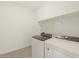 Laundry room equipped with modern washer, dryer, and upper shelf storage at 37168 W Prado St, Maricopa, AZ 85138