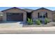 Charming single-story home with a dark garage door, desert landscaping, and neutral colored facade at 37174 W La Paz St, Maricopa, AZ 85138