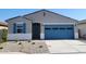 Charming single-story home featuring a blue garage door and a well-maintained, low maintenance front yard at 37198 W Vera Cruz Dr, Maricopa, AZ 85138