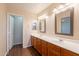 Bathroom featuring a dual sink vanity, framed mirrors, and wood-look flooring at 4010 W Fremont Rd, Phoenix, AZ 85041
