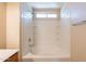Bathroom bathtub and shower combo featuring tiled walls, shelving, and a window at 4010 W Fremont Rd, Phoenix, AZ 85041