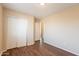 Bedroom featuring wood floors, closet with sliding white doors, and a view into an adjoining room at 4010 W Fremont Rd, Phoenix, AZ 85041