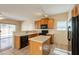 Open kitchen featuring wood cabinets, an island, and black appliances at 4010 W Fremont Rd, Phoenix, AZ 85041