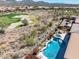 Aerial view showcasing the pool, fire pit and golf course in this desert home's backyard at 41819 N Anthem Ridge Dr, Phoenix, AZ 85086
