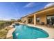 Beautiful backyard features a pool with waterfall, hot tub, covered patio, and desert landscape at 41819 N Anthem Ridge Dr, Phoenix, AZ 85086