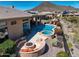 Aerial view of backyard featuring a pool, spa, fire pit, covered patio and desert landscaping at 41819 N Anthem Ridge Dr, Phoenix, AZ 85086