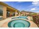 Expansive backyard featuring a pool, spa, covered patio, and outdoor kitchen, ideal for entertaining at 41819 N Anthem Ridge Dr, Phoenix, AZ 85086