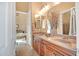 Bathroom features a wood vanity, double sinks, decorative mirror and bedroom access at 41819 N Anthem Ridge Dr, Phoenix, AZ 85086