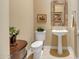 Stylish powder room with pedestal sink, decorative mirror and tiled floors at 41819 N Anthem Ridge Dr, Phoenix, AZ 85086