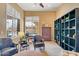 Comfortable living room featuring built-in bookcases, shutters, neutral walls, and a ceiling fan at 41819 N Anthem Ridge Dr, Phoenix, AZ 85086