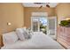 Bright bedroom featuring a ceiling fan, white bedding, dresser, and backyard access at 41819 N Anthem Ridge Dr, Phoenix, AZ 85086