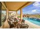Inviting covered patio features outdoor dining area, built-in grill, and access to a sparkling pool at 41819 N Anthem Ridge Dr, Phoenix, AZ 85086