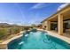 Lush backyard with pool, waterfall, patio, hot tub, and desert landscape with mountain views at 41819 N Anthem Ridge Dr, Phoenix, AZ 85086