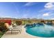 Inviting backyard pool with waterfall and lounge chairs, offering scenic mountain views at 41819 N Anthem Ridge Dr, Phoenix, AZ 85086