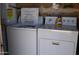 A white washing machine and dryer stand side-by-side in a laundry area at 4550 W Cinnabar Ave, Glendale, AZ 85302
