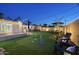 Spacious backyard offering a putting green, lounge seating, dining area, and ambient string lights for evening gatherings at 4714 N Miller Rd, Scottsdale, AZ 85251