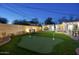 Relaxing backyard features a putting green, lounge chairs, an outdoor dining area and covered hot tub area at 4714 N Miller Rd, Scottsdale, AZ 85251