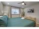 Well-lit bedroom featuring a ceiling fan, flatscreen TV, and a cozy queen bed, creating a relaxing ambiance at 4714 N Miller Rd, Scottsdale, AZ 85251