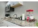 Well-equipped kitchenette with stainless steel microwave, granite countertops, and ample storage, ideal for snacking at 4714 N Miller Rd, Scottsdale, AZ 85251