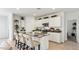 Bright kitchen featuring white cabinets, stainless steel appliances, an island with bar seating and stone countertops at 48401 N Duran Way, Gold Canyon, AZ 85118