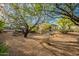 Landscaped backyard with gravel, trees, and patio area, offering a serene outdoor space at 6069 E Ironwood Dr, Scottsdale, AZ 85266