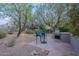 Outdoor patio with a built-in grill, seating area, and mature desert landscaping at 6069 E Ironwood Dr, Scottsdale, AZ 85266