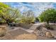 Backyard patio with seating, built-in grill, stone steps, and desert landscaping at 6069 E Ironwood Dr, Scottsdale, AZ 85266