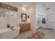 Bright bathroom featuring dual vanities, walk-in shower, and soaking tub at 6069 E Ironwood Dr, Scottsdale, AZ 85266