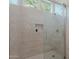 Modern bathroom with a tiled walk-in shower, built-in niche, and glass door at 6069 E Ironwood Dr, Scottsdale, AZ 85266