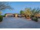 Home exterior with stone accents, lush desert landscaping, and a spacious driveway at 6069 E Ironwood Dr, Scottsdale, AZ 85266