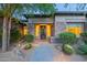 Welcoming front entrance with desert landscaping, stone accents, and illuminated pathway at 6069 E Ironwood Dr, Scottsdale, AZ 85266