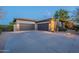 This house features a spacious three car garage and a long driveway with desert landscaping at 6069 E Ironwood Dr, Scottsdale, AZ 85266