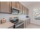 Kitchen with stainless steel appliances, quartz countertops, and gray cabinetry at 6069 E Ironwood Dr, Scottsdale, AZ 85266