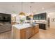 Open kitchen showcases a large island with sink, stainless steel appliances, and views of the living area at 6069 E Ironwood Dr, Scottsdale, AZ 85266