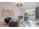 Bright living room features stylish decor, gray upholstered chairs, light wood floors, and modern lighting fixture at 6069 E Ironwood Dr, Scottsdale, AZ 85266