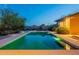 A beautiful backyard pool reflects the twilight sky, surrounded by desert landscaping at 6069 E Ironwood Dr, Scottsdale, AZ 85266