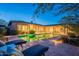 Inviting pool surrounded by patio seating and desert landscape in the evening at 6069 E Ironwood Dr, Scottsdale, AZ 85266